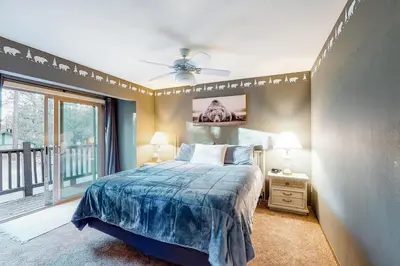 a bedroom with a bed and a large window at Rosie's Hideaway ~ Spacious Retreat Near the Mountain & Lake with Grill & Full Kitchen in Big Bear Lake