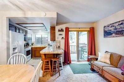 a kitchen and living room with a couch and a table at Rosie's Hideaway ~ Spacious Retreat Near the Mountain & Lake with Grill & Full Kitchen in Big Bear Lake