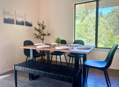 a dining room table with chairs and a table and a window at Brentwood Haus in Lake Arrowhead