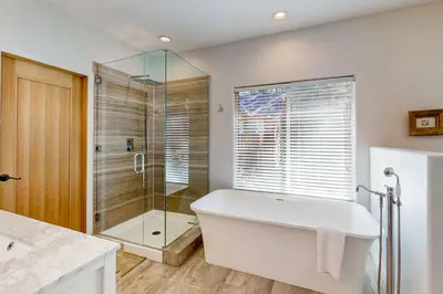 a bathroom with a tub and a glass shower at Hillside Hideaway ~ Dog-friendly home with wraparound deck, grill, game room, & bar - walk to dining in Big Bear Lake