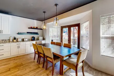 a kitchen with a dining room table and chairs at Hillside Hideaway ~ Dog-friendly home with wraparound deck, grill, game room, & bar - walk to dining in Big Bear Lake