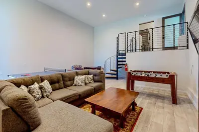 a living room with a couch and a table at Hillside Hideaway ~ Dog-friendly home with wraparound deck, grill, game room, & bar - walk to dining in Big Bear Lake