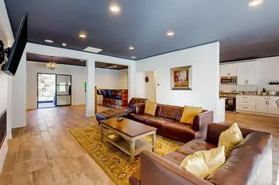 a living room with leather couches and a table at Hillside Hideaway ~ Dog-friendly home with wraparound deck, grill, game room, & bar - walk to dining in Big Bear Lake