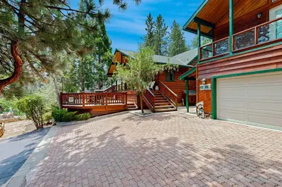 a house with a garage and a driveway at Rooster's Den ~ Charming house with expansive deck, cable, internet, near Big Bear Lake in Big Bear Lake