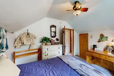 a bedroom with a blue bed and a wooden dresser at Rooster's Den ~ Charming house with expansive deck, cable, internet, near Big Bear Lake in Big Bear Lake