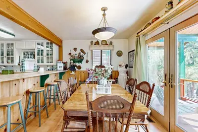 a dining room with a wooden table and chairs at Rooster's Den ~ Charming house with expansive deck, cable, internet, near Big Bear Lake in Big Bear Lake