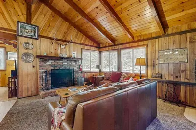 a living room with a couch and a fireplace at Idle Ours Cabin ~ Rustic and Cozy Cabin with Fireplace & Private BBQ - Walk to Big Bear Lake in Fawnskin