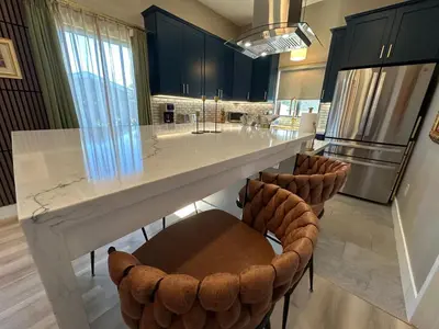 a kitchen with a large white counter and stools at Stylish Highland Park Home in Los Angeles