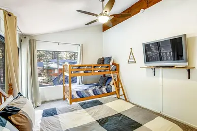 a bedroom with a bunk bed and a flat screen tv at Summit Hideaway ~ Fantastic Mountain getaway with private hot tub, free Wi-Fi, full kitchen, & more in Big Bear Lake