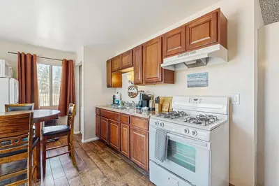 a kitchen with wooden cabinets and a white stove top oven at Meadow-Front Metcalf Bay Cabin Hot Tub, Air Hockey, Firepit & Lake Views in Big Bear Lake
