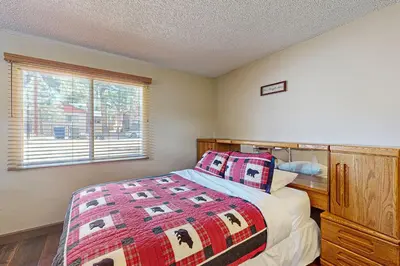 a bedroom with a bed with a quilt and a window at Meadow-Front Metcalf Bay Cabin Hot Tub, Air Hockey, Firepit & Lake Views in Big Bear Lake