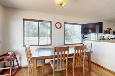 a kitchen with a table and chairs and a clock at Lazy Bear Cabin ~ Dog-friendly home with private hot tub, ping-pong, basketball & firepit in Big Bear Lake