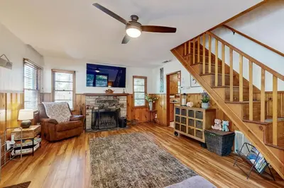 a living room with a ceiling fan and a staircase at Quiet Cabin ~ End of Cul-De-Sac Location Private Hot Tub, Fenced Yard, Boat Parking in Big Bear Lake