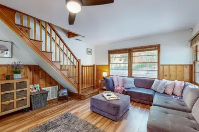 a living room with a couch and a staircase at Quiet Cabin ~ End of Cul-De-Sac Location Private Hot Tub, Fenced Yard, Boat Parking in Big Bear Lake