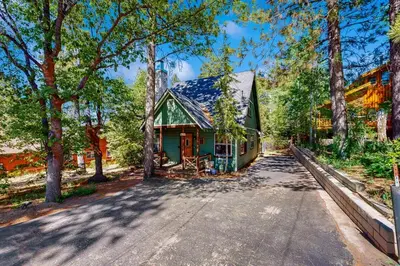an empty road in front of a house with trees at Quiet Cabin ~ End of Cul-De-Sac Location Private Hot Tub, Fenced Yard, Boat Parking in Big Bear Lake
