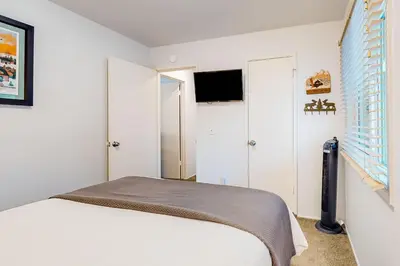 a white bedroom with a bed and a window at Moose-in' Around ~ Walk to Slopes Mountain Home with Private Hot Tub, Ski Locker & Playground in Big Bear Lake