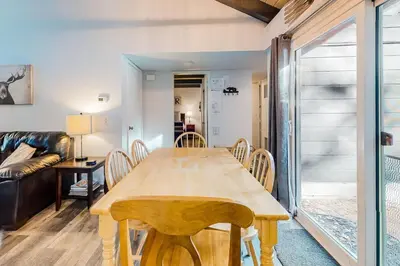 a dining room with a wooden table and chairs at Moose-in' Around ~ Walk to Slopes Mountain Home with Private Hot Tub, Ski Locker & Playground in Big Bear Lake