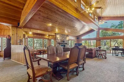 a dining room with a table and a living room at Big Bear 7th Heaven ~ Lakeview Chalet with Hot Tub, Sauna, Grill, Great Deck Views in Fawnskin