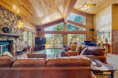a living room with a couch and a fireplace at Big Bear 7th Heaven ~ Lakeview Chalet with Hot Tub, Sauna, Grill, Great Deck Views in Fawnskin