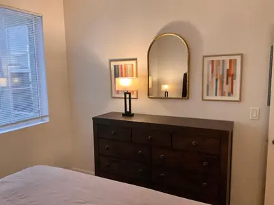 a bedroom with a dresser with a lamp and a mirror at Luxe Stay Marina Del Rey in Los Angeles