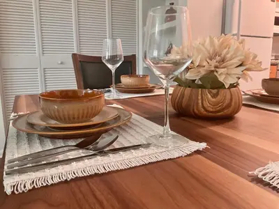 a table with plates and wine glasses on a wooden table at Luxe Stay Marina Del Rey in Los Angeles