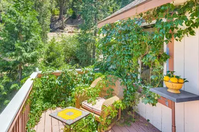 a balcony with a chair and a table at Forest Views and Fire Pit! Cozy Cabin in Crestline in Crestline