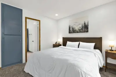 a bedroom with a large white bed and two lamps at The Fox Den Big Bear ~ Modern Mountain View Retreat w/ Hot Tub in Big Bear City