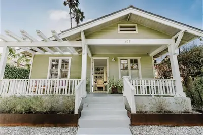a green house with a white pergola at Venice 2BR and Guest Studio with Tub & Garden in Los Angeles