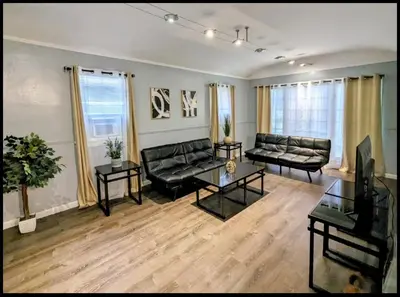 a living room with two couches and a table at Spacious 3 bedroom home by Melrose and 10 minutes to Hollywood Walk of Fame in Los Angeles