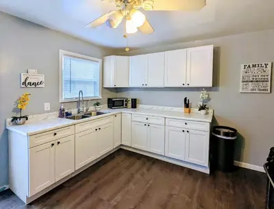 a kitchen with white cabinets and a ceiling fan at Spacious 3 bedroom home by Melrose and 10 minutes to Hollywood Walk of Fame in Los Angeles