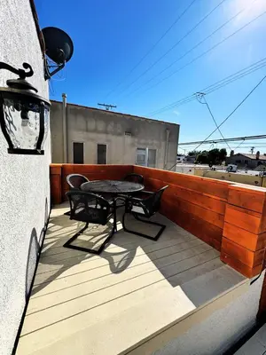a patio with a table and chairs on a balcony at Beach Life in Belmont Shore in Long Beach