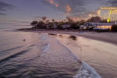 a beach with a person walking in the water at The Cove at Rincon by Paradise Retreats in Carpinteria