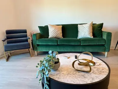 a living room with a green couch and a coffee table at Silver Lake 1 Bedroom Condo Suite with Balcony and Parking in Los Angeles