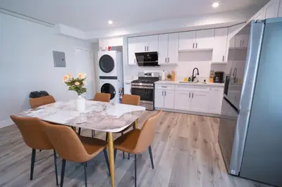 a kitchen with white cabinets and a table and chairs at Modern 2BR2BA Home Near USC Walk to Campus in Los Angeles