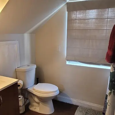 a bathroom with a white toilet and a window at BH Adj, studio spacious BH in Los Angeles