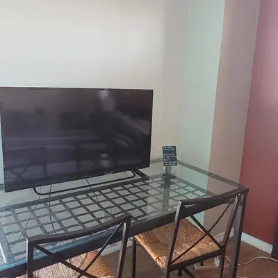 a glass table with a television on top of it at BH Adj, studio spacious BH in Los Angeles