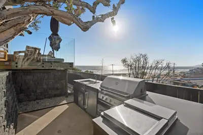 a outdoor kitchen with a stove and a tree at Surfside Malibu by Stay Awhile Villas in Malibu
