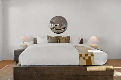 a bedroom with a large bed and a mirror on the wall at Surfside Malibu by Stay Awhile Villas in Malibu