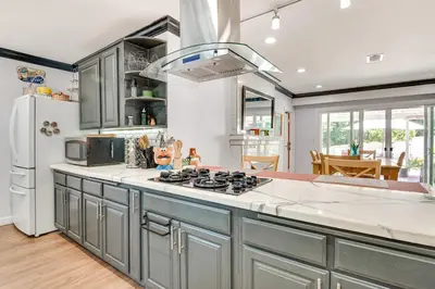 a kitchen with a stove and a refrigerator at Relax Fireside Hacienda Heights Gem with Patio! in Hacienda Heights