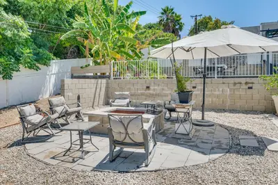 a patio with a table and chairs and an umbrella at Relax Fireside Hacienda Heights Gem with Patio! in Hacienda Heights