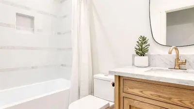 a bathroom with a sink and a toilet and a mirror at Luxury Retreat 5mins to the Lake Game Room Fire Pit Howlite by AvantStay in Lake Arrowhead
