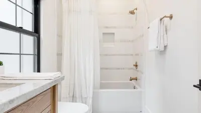 a white bathroom with a tub and a toilet and a sink at Luxury Retreat 5mins to the Lake Game Room Fire Pit Howlite by AvantStay in Lake Arrowhead