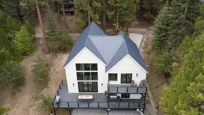 an aerial view of a white house with a blue roof at Luxury Retreat 5mins to the Lake Game Room Fire Pit Howlite by AvantStay in Lake Arrowhead