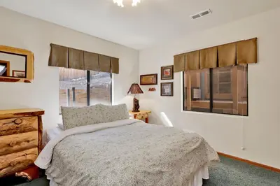a bedroom with a bed and a dresser and two windows at Big Bear 7th Heaven #714 in Fawnskin
