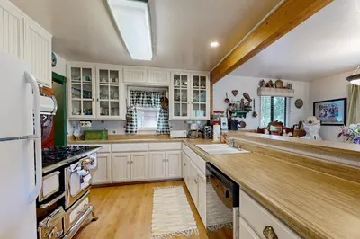 a kitchen with white cabinets and a wooden counter top at Rooster's Den #710 in Big Bear Lake