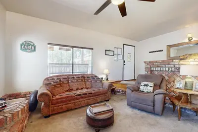 a living room with a large bed and a chair at Lazy Bear Cabin #554 in Big Bear Lake