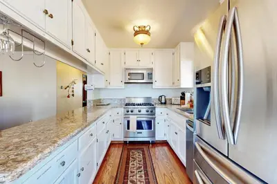 a kitchen with white cabinets and a refrigerator at Lazy Bear Cabin #554 in Big Bear Lake