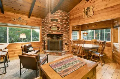 a living room with a fireplace in a log cabin at Orchard Family Cabin #2560 in Big Bear Lake