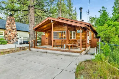 a wooden cabin with a table and a chair at Orchard Family Cabin #2560 in Big Bear Lake