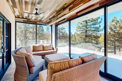 a living room with a couch and chairs and windows at Hillside Hideaway #603 in Big Bear Lake